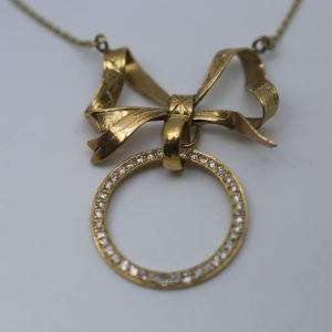 Colgante oro 18  kilates y diamantes con forma de lazo